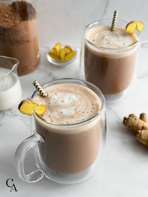 Hot chocolate with a slice of ginger and almond milk foam.