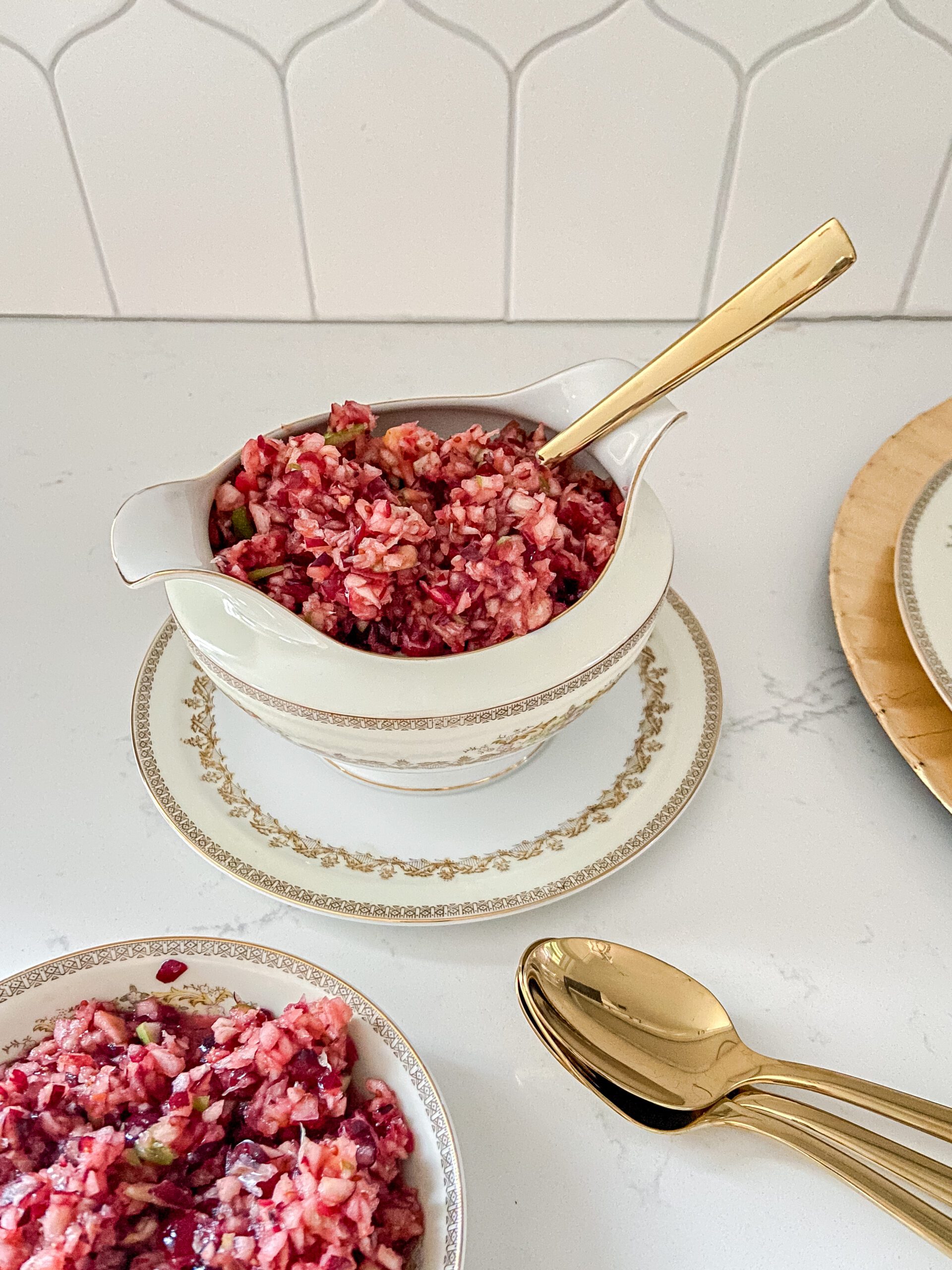 Cranberry relish in a gravy boat with a gold spoon.