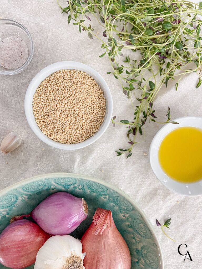 Bowls of shallots, millet and olive oil on a linen cloth.