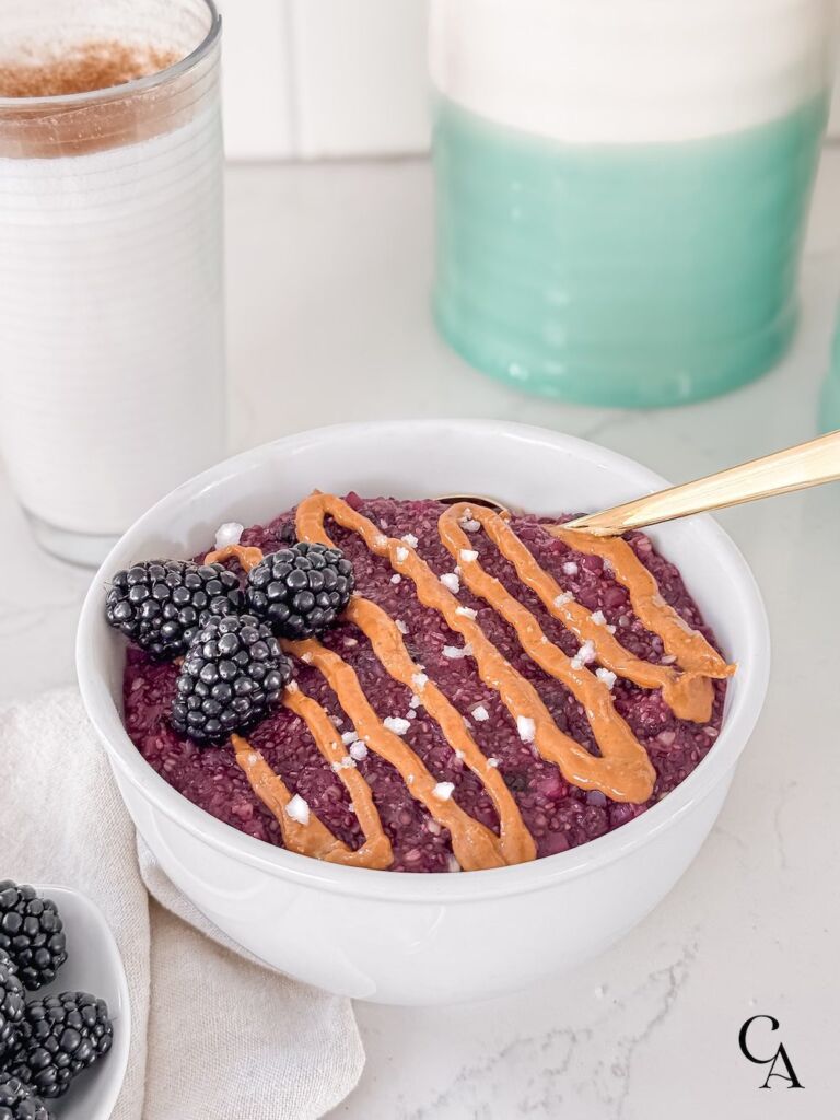 A bowl of oats with nut butter and berries.