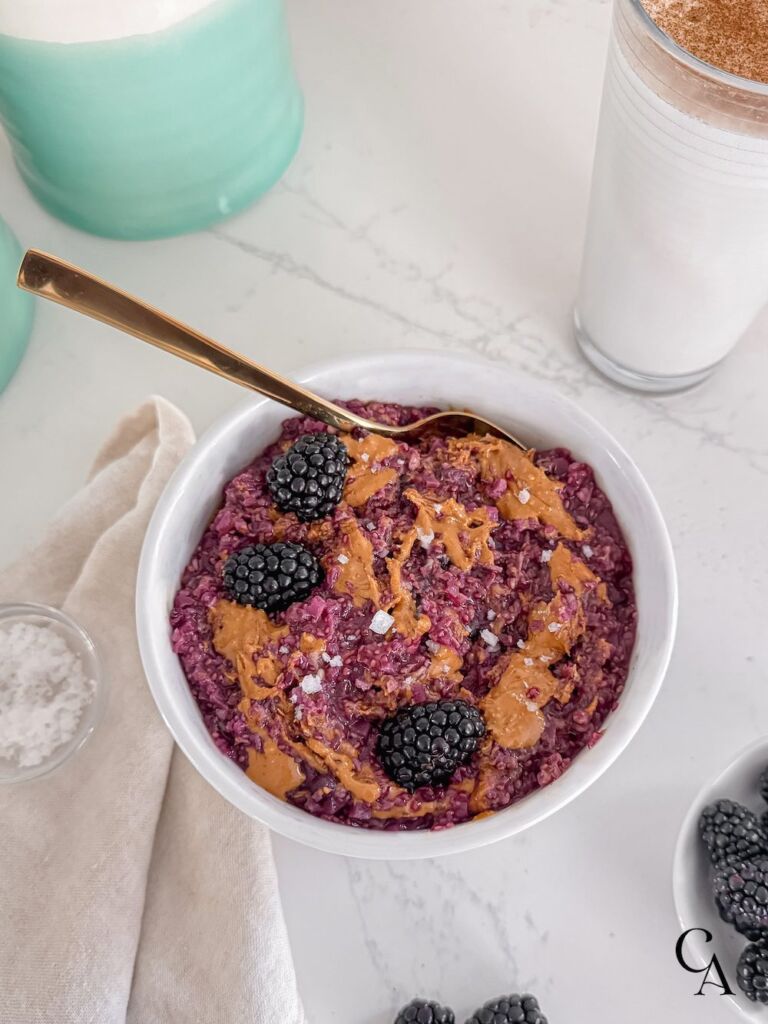 A bowl of breakfast with a glass of milk next to a kitchen canister.