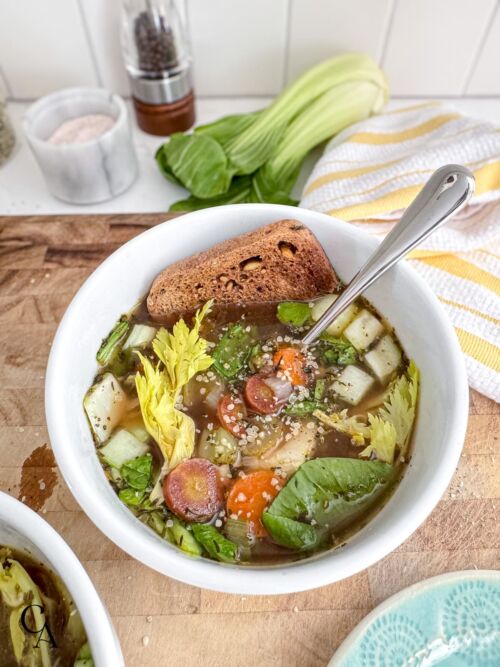 A bowl of bone broth vegetable soup and toast.