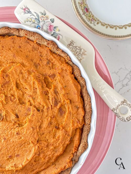 A sweet potato tart on a pink cake stand.