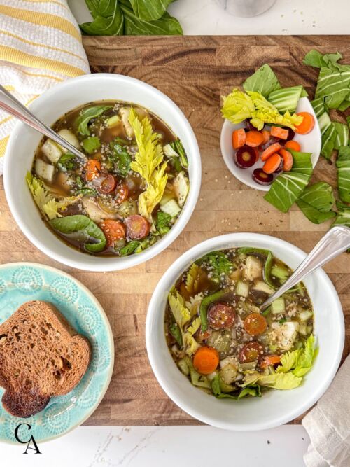Bowls of soup with vegetables and toast.