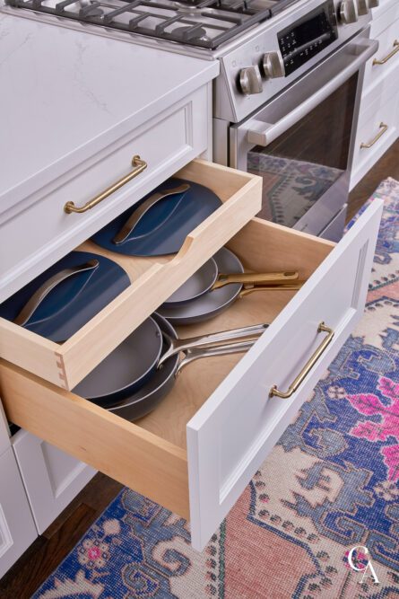 Kitchen cabinet drawers with pots and pans inside.