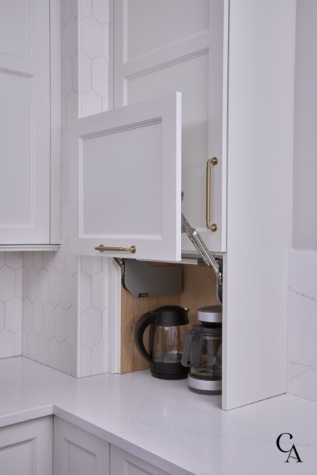 A hidden coffee and tea station in a white cabinet.