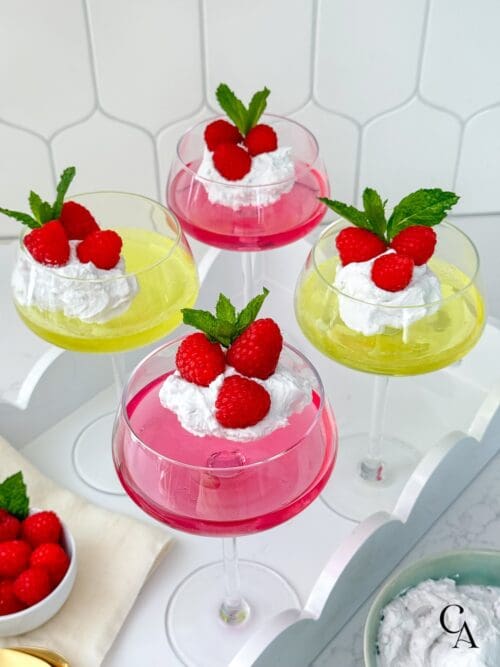 A tray of sugar-free jello cups topped with coconut whipped cream and berries.