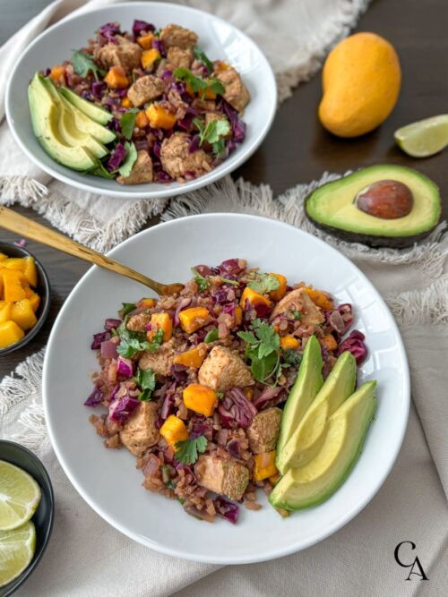 Bowls of mango slaw on rice, with avocado slices.