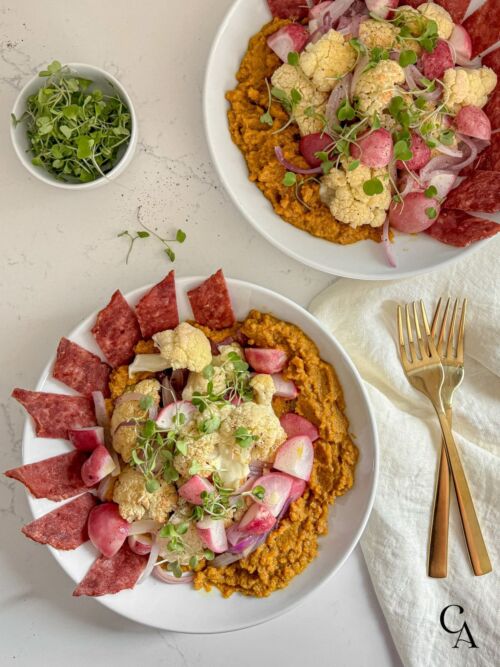 Bowls of cauliflower and radishes with puréed golden beets and bacon.