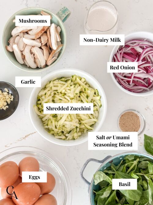 Bowls of zucchini spirals, red onion, shiitake mushrooms, basil, eggs and almond milk to make a frittata.