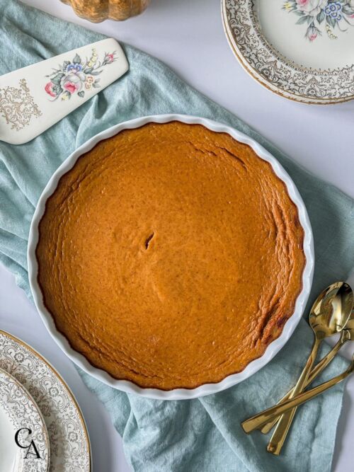 A crustless pumpkin pie on a white table.