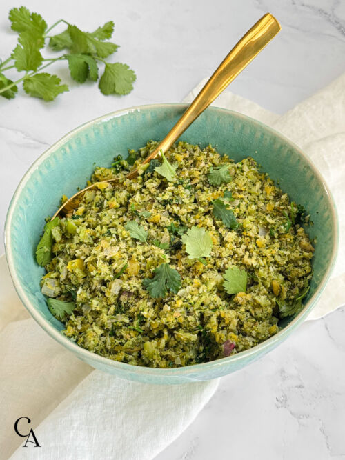 A turquoise bowl of riced broccoli with cilantro.