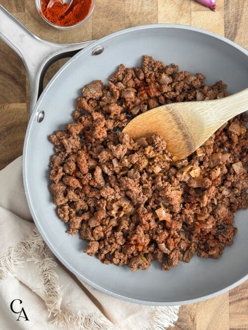 A pan of ground meat on a cutting board.
