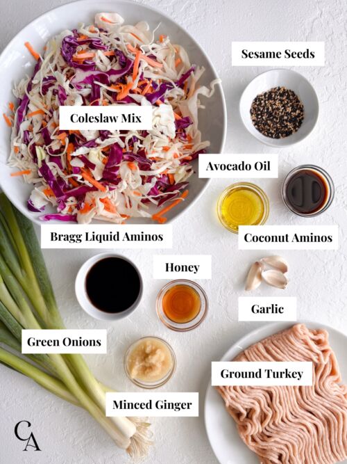 Flat lay of ingredients for egg roll in a bowl, including ground turkey, coleslaw mix, and seasonings.
