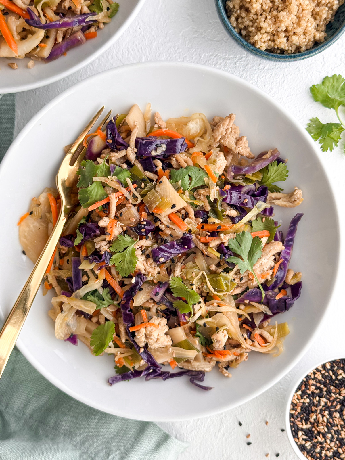 Bowl of egg roll in a bowl with ground turkey, shredded cabbage, carrots, and cilantro.