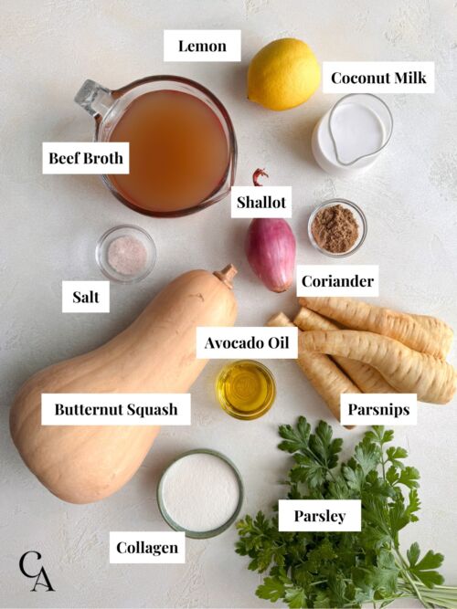 Flat lay of labeled ingredients, including butternut squash, parsnips, coconut milk, beef broth, shallot, parsley, and coriander.