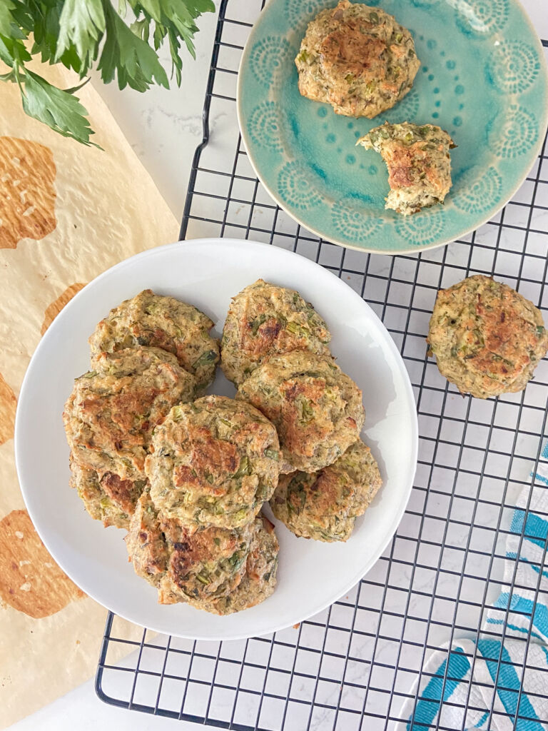 Plates of salmon patties on a black wire cooling rack, over a light counter.