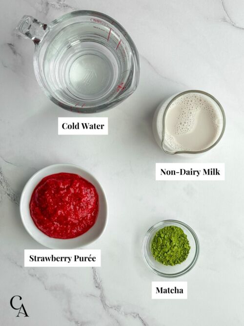 Overlay of ingredients, including a cup of water, a pitcher of non-dairy milk, and small bowls of matcha powder and puréed strawberries.